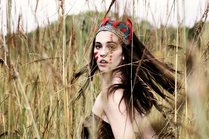 Woman with face paint in tall grass
