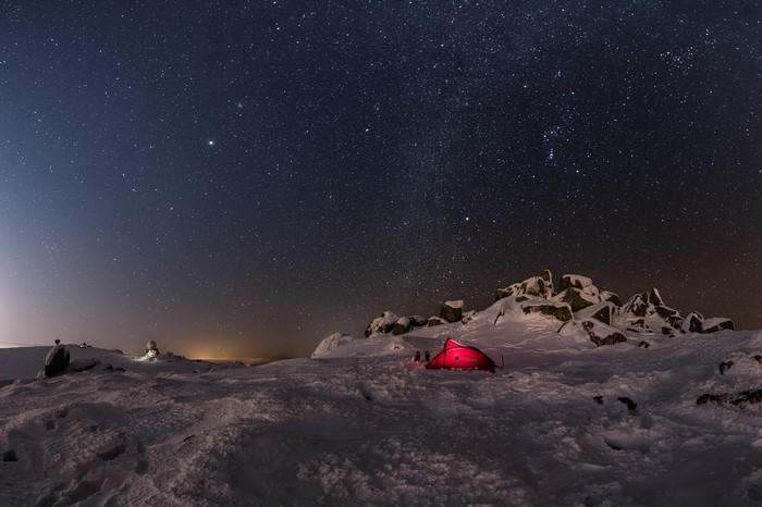 Winter night camping under starry sky