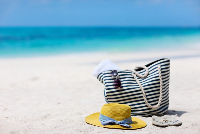 Beach accessories on sand with ocean background