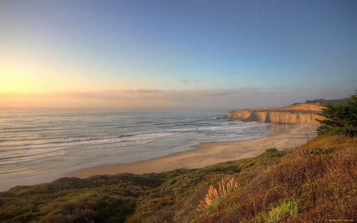 Coastal cliffs and ocean at sunset