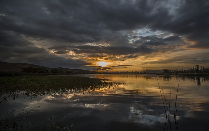 Sunset over a lake with dark clouds