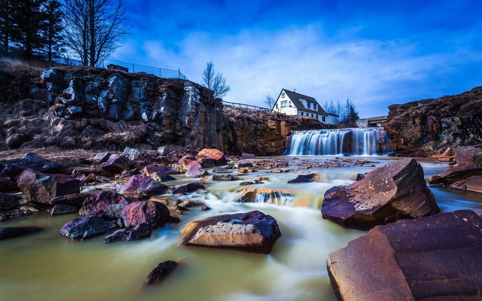 Waterfall with a house and rocks