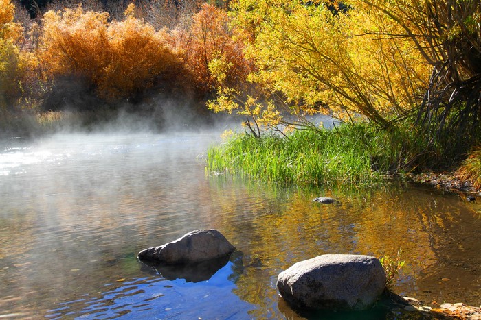 Misty River in Autumn with Colorful Trees and Rocks