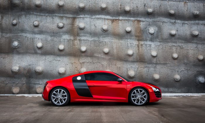 Red Audi R8 parked against a textured wall