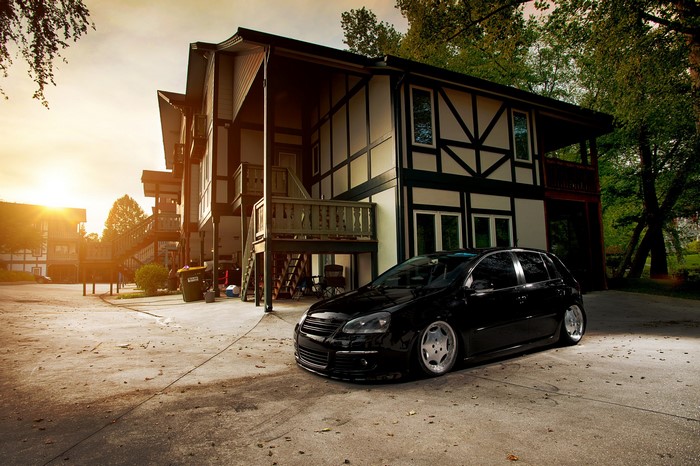 Black Volkswagen Golf MK5 parked near houses