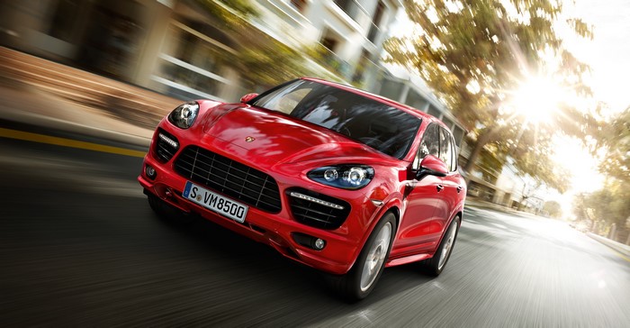 Red Porsche Cayenne driving on a street
