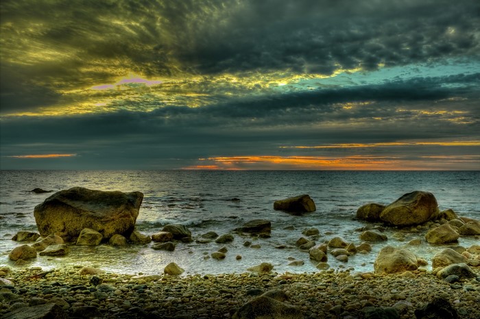 Rocky Coastline Under Dramatic Sunset Sky