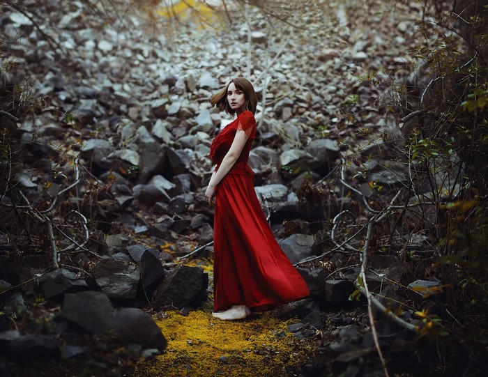 Woman in red dress in rocky terrain