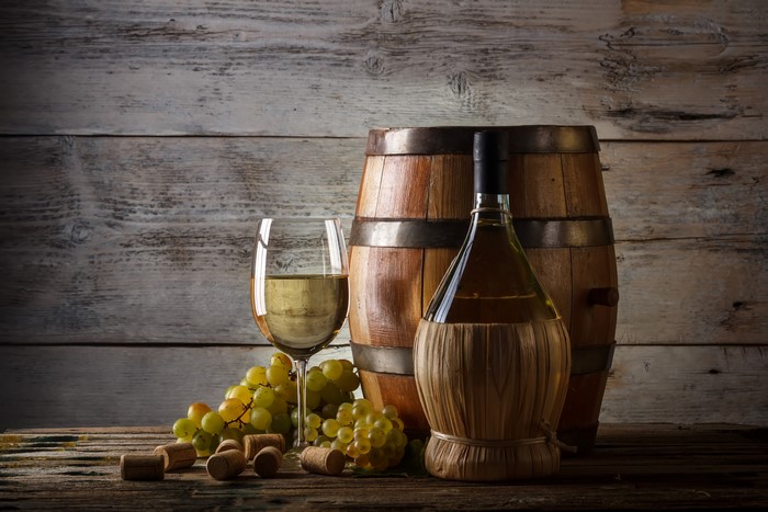 Wine bottle, glass, grapes, and barrel