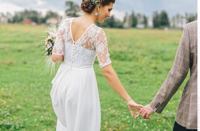 Bride and Groom holding hands in a field