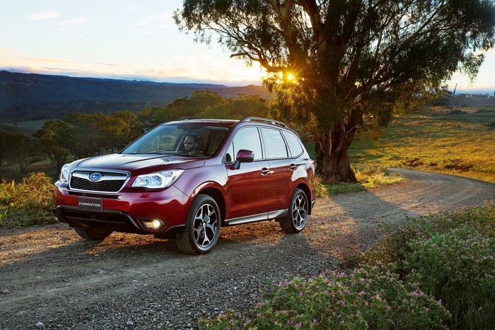 Red Subaru Forester on a dirt road at sunset