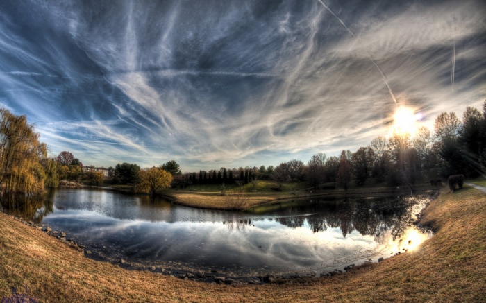 Pond with trees and dramatic sky