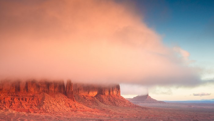 Monument Valley mesas shrouded in fog at sunrise