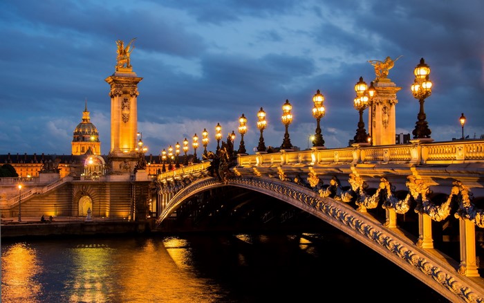 Pont Alexandre III bridge over the Seine River in Paris at night