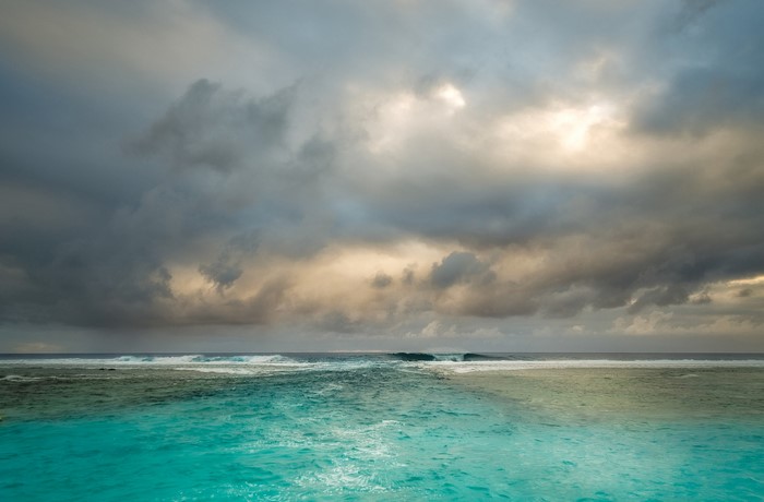 Ocean waves under stormy clouds at horizon