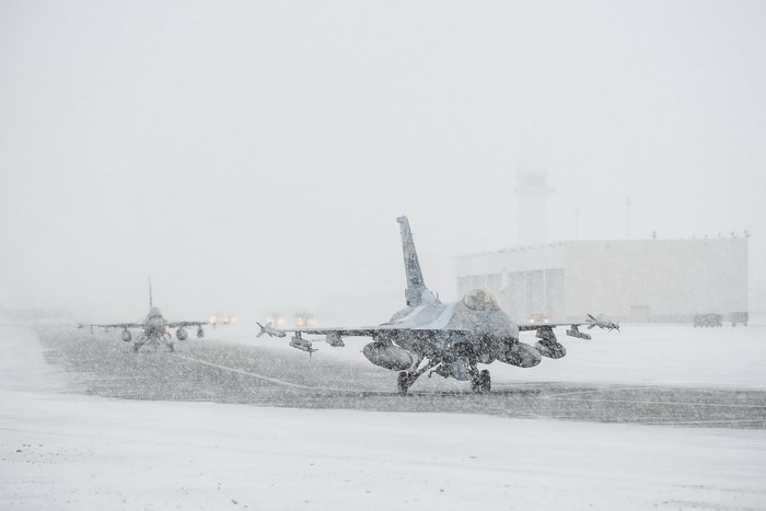 F-16 Fighting Falcons taxiing in snow