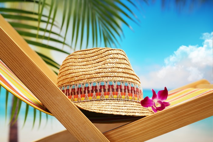 Summer beach scene with straw hat and flower
