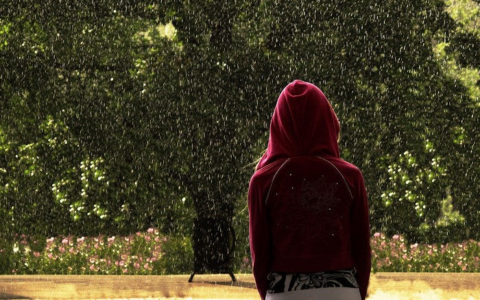 Girl in red hoodie standing in the rain