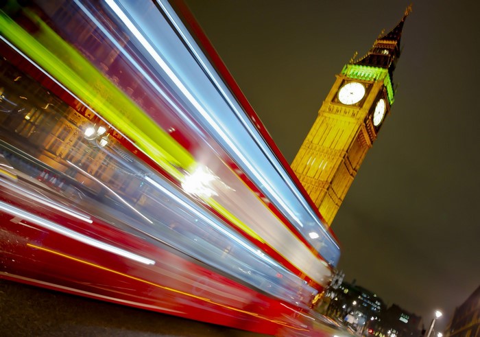 Big Ben and a red bus in London at night