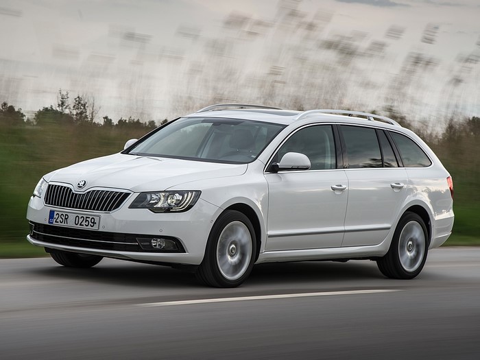 White Skoda Superb Combi driving on a road