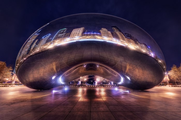 Cloud Gate sculpture reflecting Chicago skyline at night