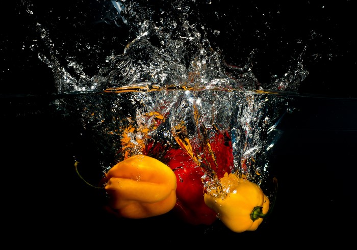 Bell peppers splashing into water