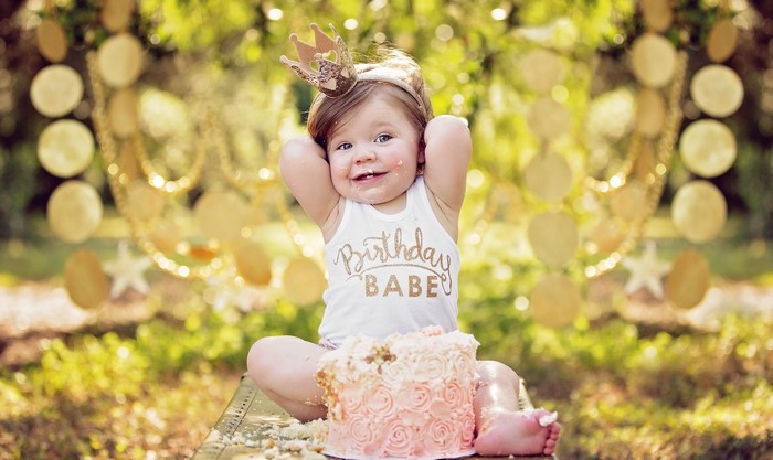 Baby girl with crown and birthday cake