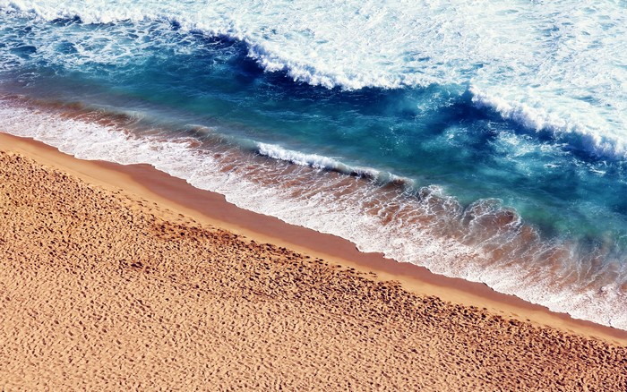 Ocean waves crashing on a sandy beach