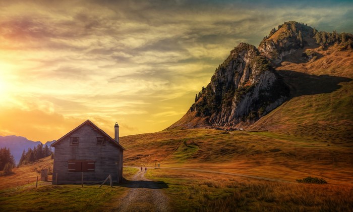 Wooden house in mountains at sunset