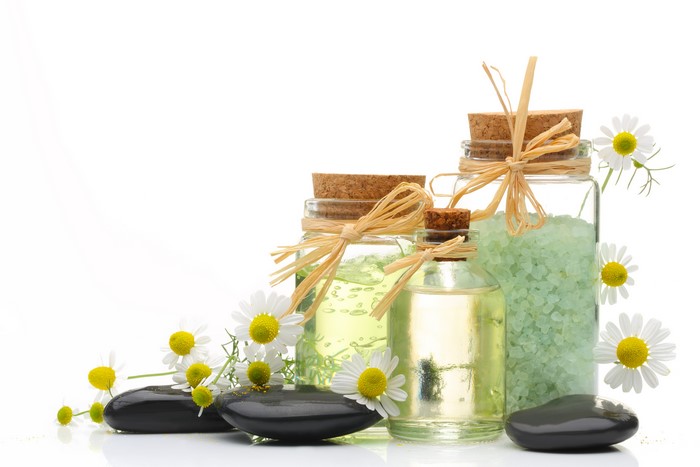 Spa bottles with chamomile flowers and stones