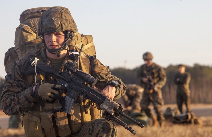 US Marines in formation with rifles and backpacks