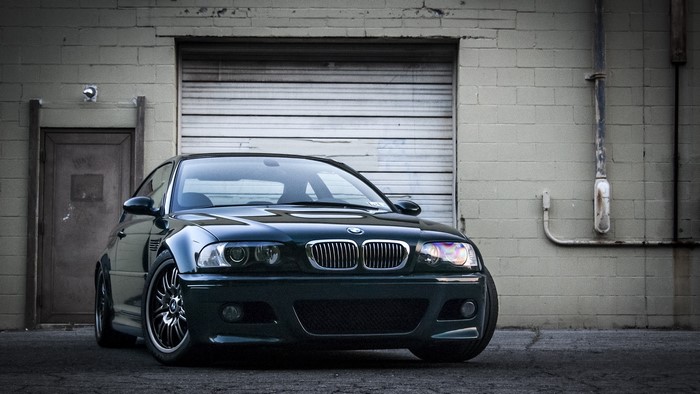 Dark Green BMW E46 M3 parked in front of a garage