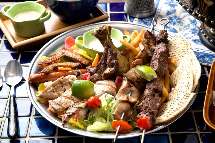 Assortment of grilled meats and sides on a platter