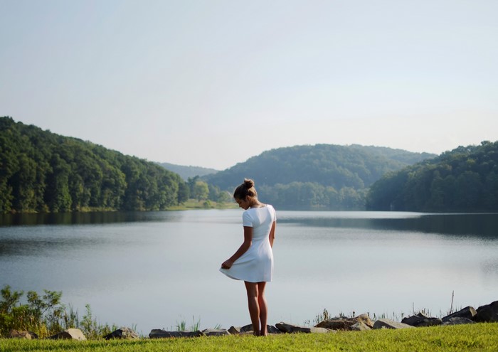 Woman in white dress by a lake