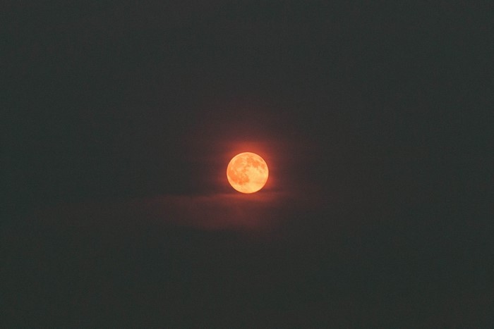 Red and orange moon in dark sky