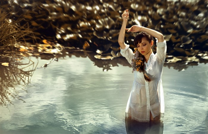 Woman in white dress standing in water