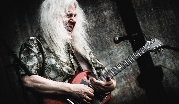 Howard Glazer playing a red electric guitar