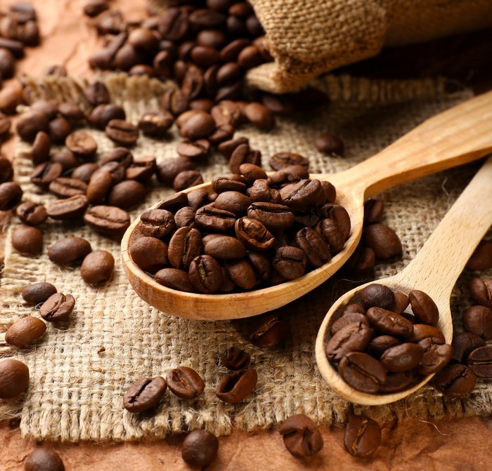 Coffee beans in wooden spoons and burlap sack