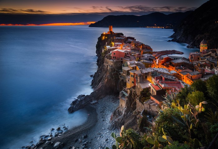 Vernazza village on a cliff overlooking the sea at sunset, Italy