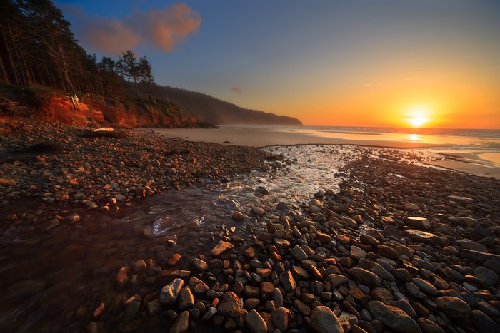 Sunset over Cape Lookout Beach with stream and stones