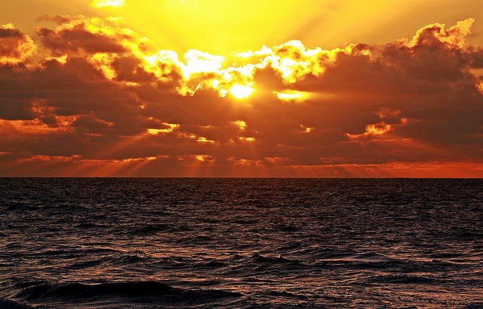 Sunset over the ocean with dramatic clouds