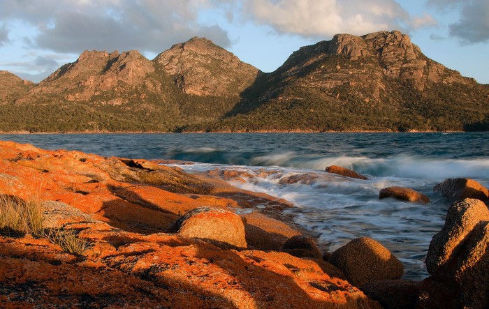 Orange rocks and mountains by the sea