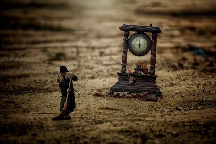 Girl sweeping near an antique clock with foliage