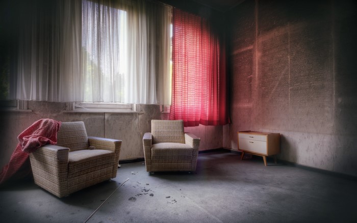 Abandoned room with armchairs and dresser