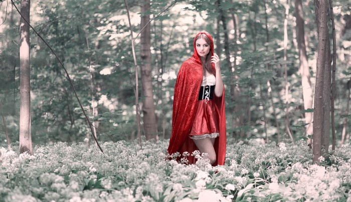 Woman in red cloak in forest