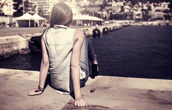 Woman sitting on a dock overlooking the water