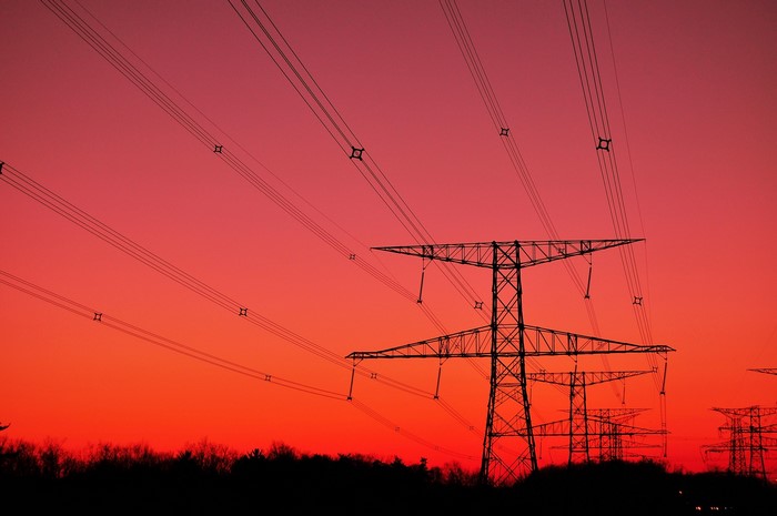 Power lines silhouetted against a sunset sky