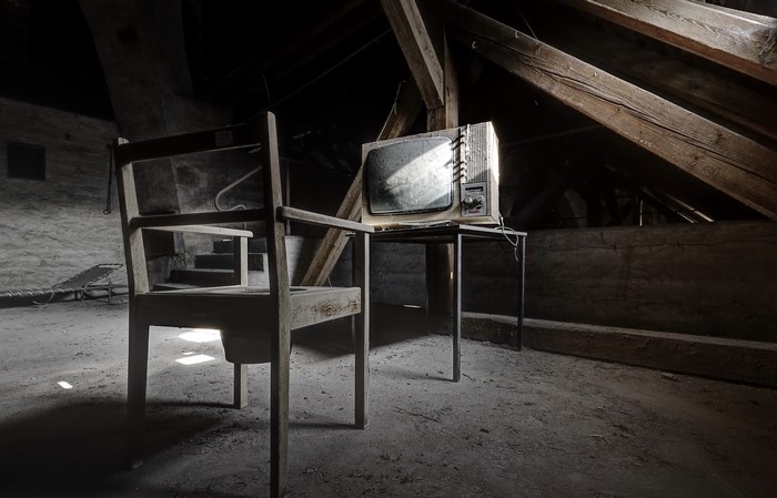 Old TV set and chair in an attic