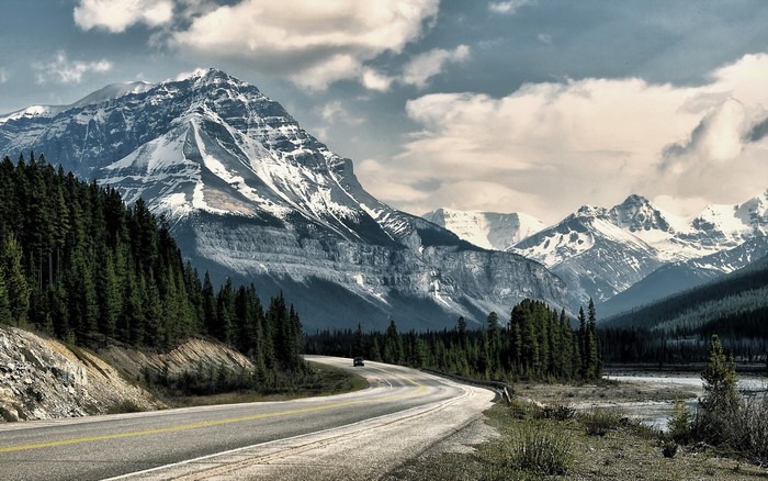 Winding Road Through Snowy Mountains and Forest