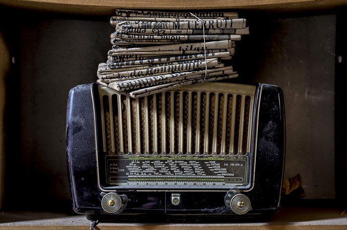Retro radio with stacked newspapers